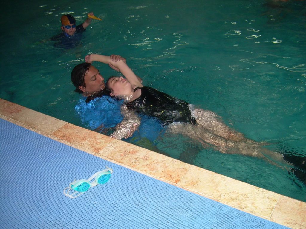 שחיה שיקומית ילדה ומטפל במים מטפל בהידרותרפיה
